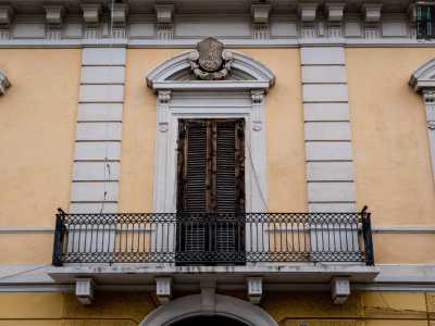 A sormontare la cornice della finestra centrale del piano superiore, scolpito a bassorilievo...
